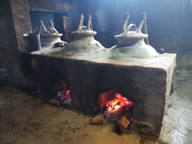 Wood fire beneath copper stills